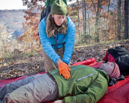 woman doing cpr on a man during the AWFA-WFR Bridge Course