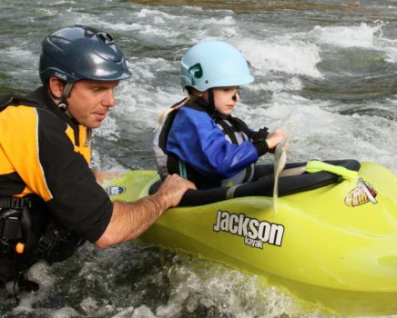 Instructor helping a child learn to kayak on the Private Canoe and Kayak Instruction course