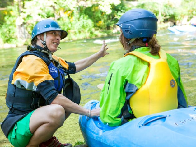 Student learning how to whitewater kayak from an instructor