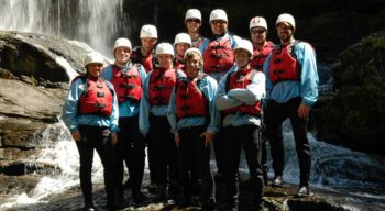 paddlers wearing helmets, life jackets, and wetsuits